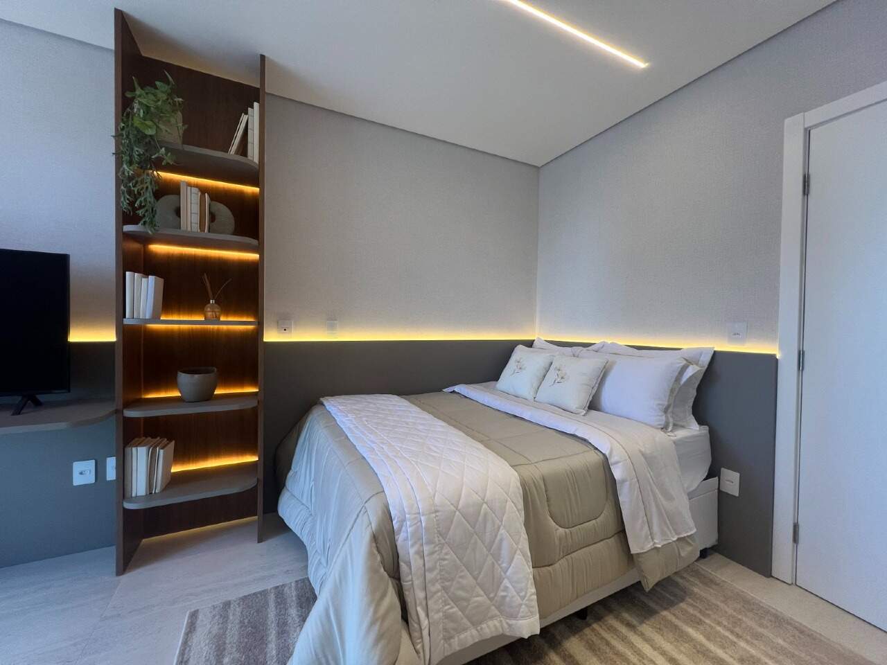 Apartamento à venda no Praia Brava: Dormitório com estante e cama de casal em apartamento decorado (foto real)