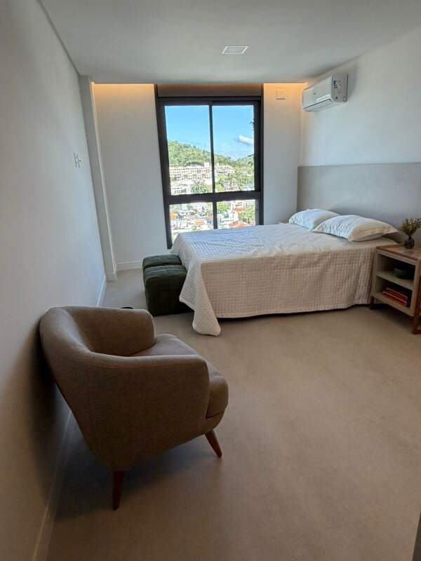 Apartamento à venda no Praia Brava: Suíte com poltrona, cama de casal e janela para os morros