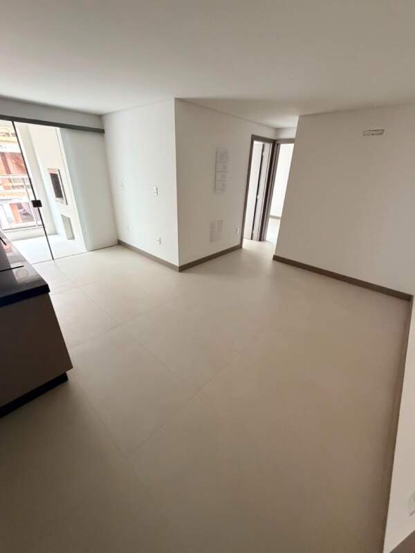 Apartamento à venda no Praia Brava: Living integrado à cozinha, com porcelanato claro e porta de vidro para a sacada