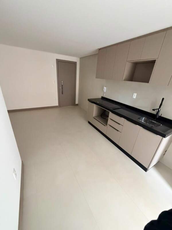 Apartamento à venda no Praia Brava: Cozinha com armários planejados, bancada escura, cooktop e cuba