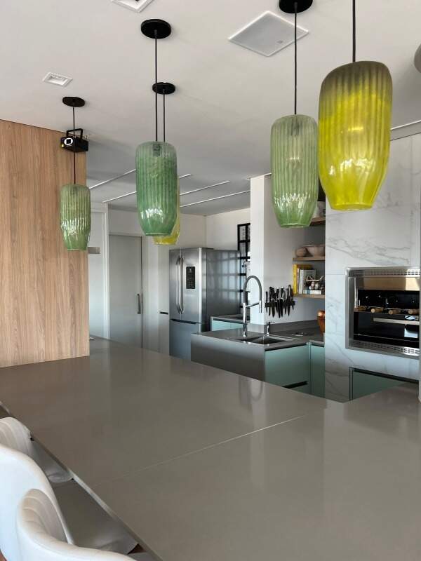 Apartamento à venda no Praia Brava: Cozinha integrada com luminárias pendentes verdes e bancada
