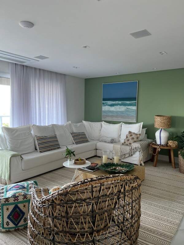 Apartamento à venda no Praia Brava: Living com sofá de canto, parede verde e poltrona de fibra