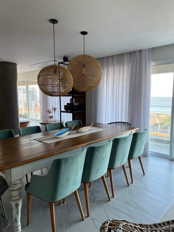 Apartamento à venda no Praia Brava: Sala de jantar com mesa longa de madeira e o mar visto pela janela