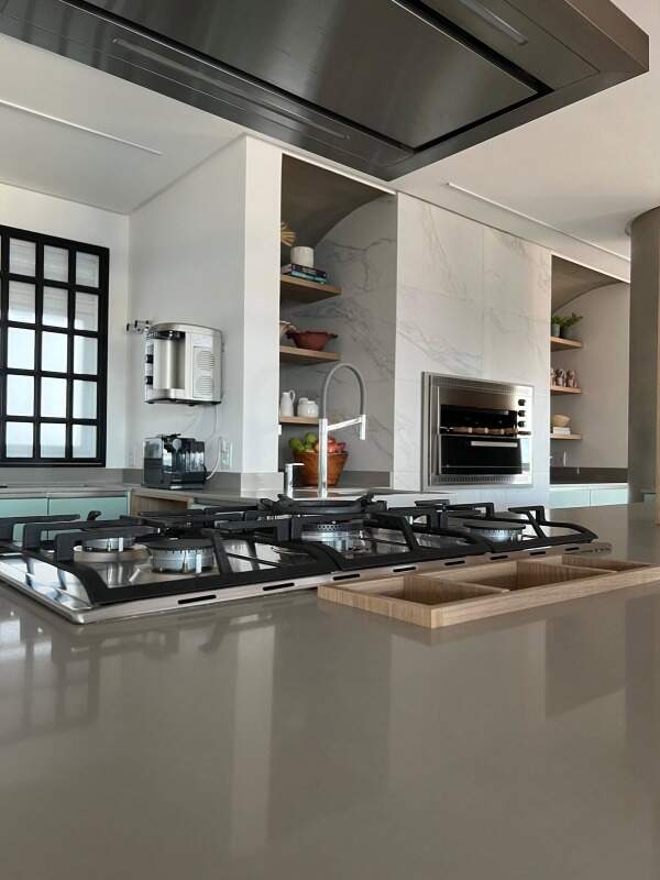 Apartamento à venda no Praia Brava: Cooktop na bancada, coifa e churrasqueira ao fundo