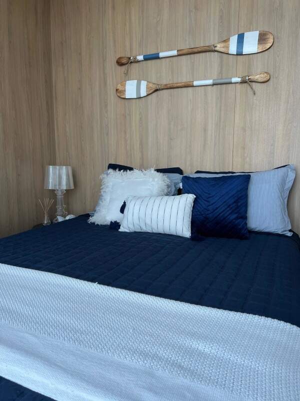 Apartamento à venda no Praia Brava: Suíte com painel de madeira e decoração náutica