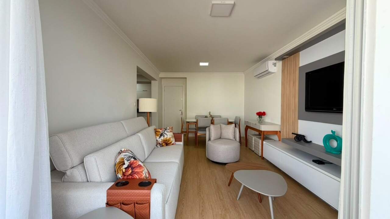 Apartamento à venda no Centro: Living com sofá, poltrona e painel para TV