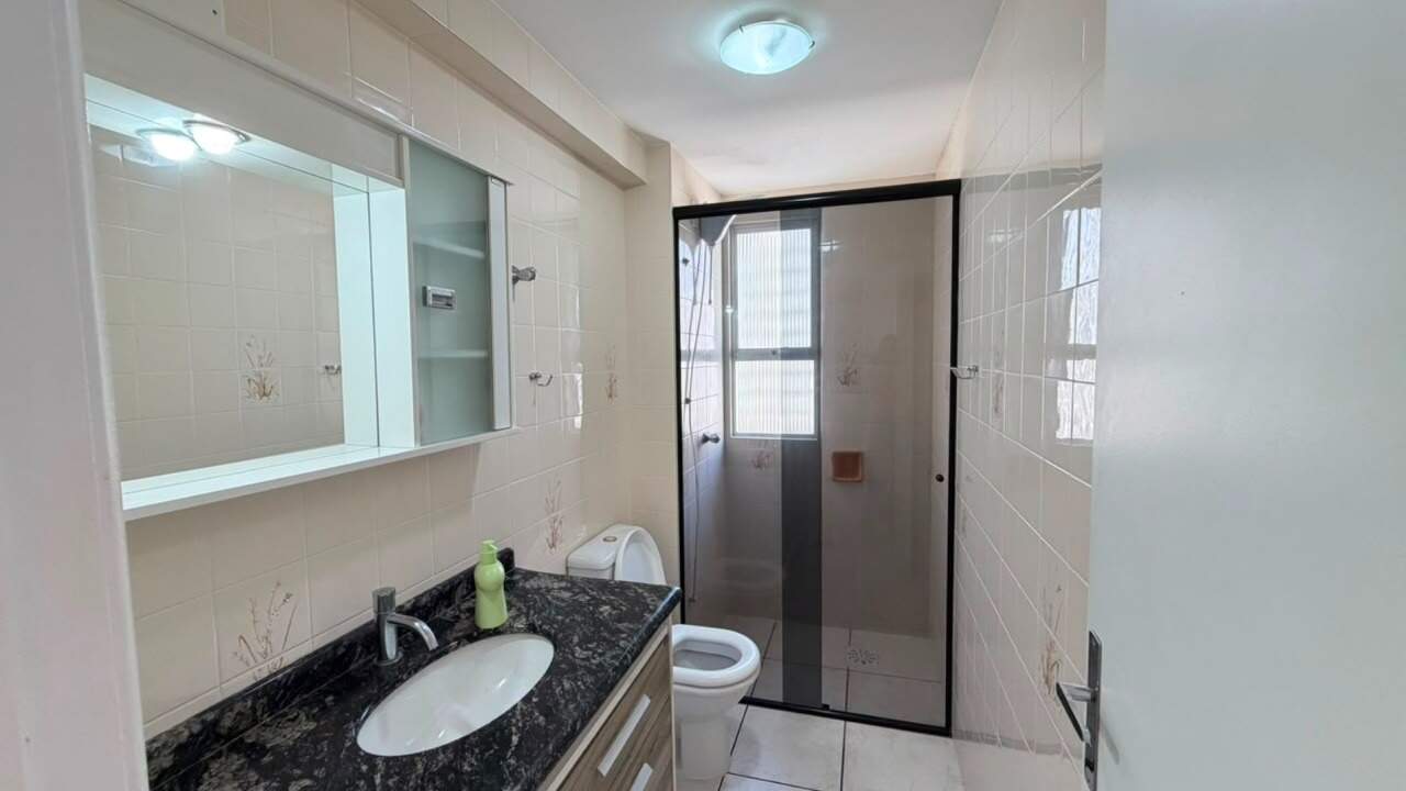 Apartamento à venda no Centro: Banheiro com bancada de granito, gabinete e box de vidro