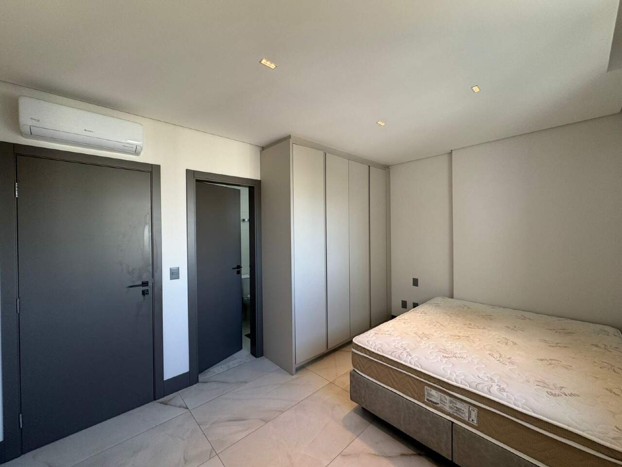 Apartamento à venda no Centro: Suíte com armário branco e ar-condicionado