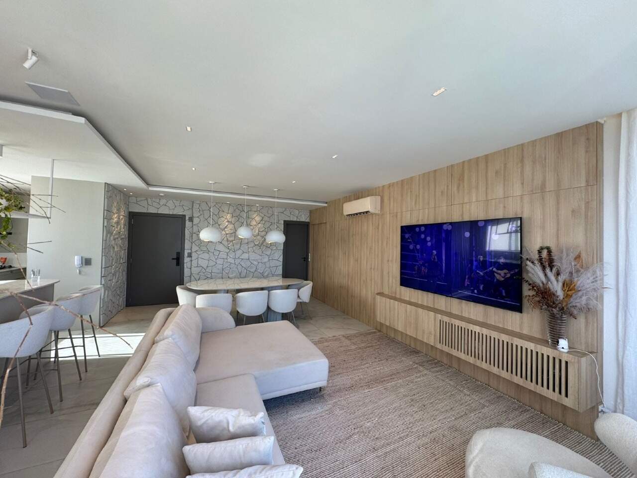 Apartamento à venda no Centro: Living com sofá, painel de madeira e TV