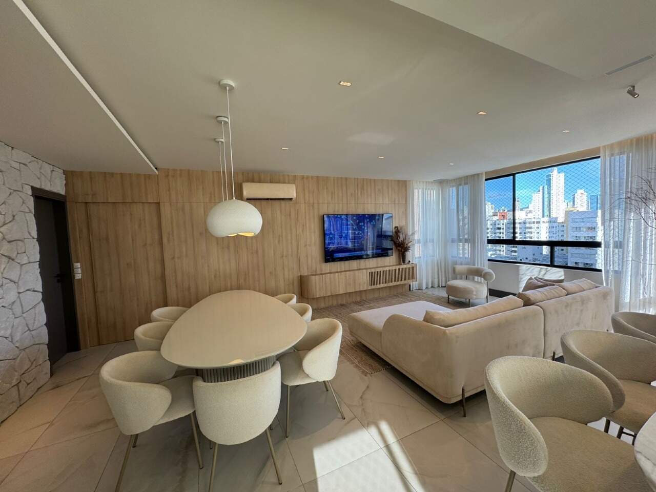 Apartamento à venda no Centro: Living e jantar integrados, com painel de madeira e janelas amplas