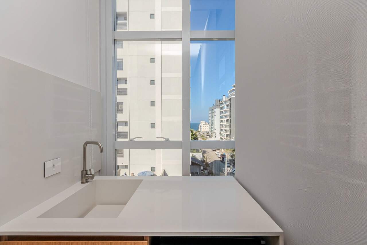 Apartamento à venda no Praia Brava: Janela da cozinha com uma faixa de mar entre os prédios