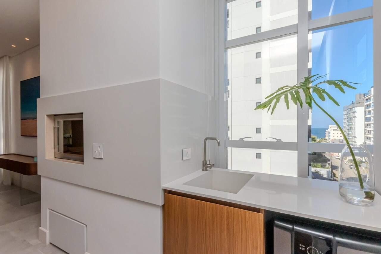 Apartamento à venda no Praia Brava: Churrasqueira e bancada com janela para os prédios e o mar ao fundo
