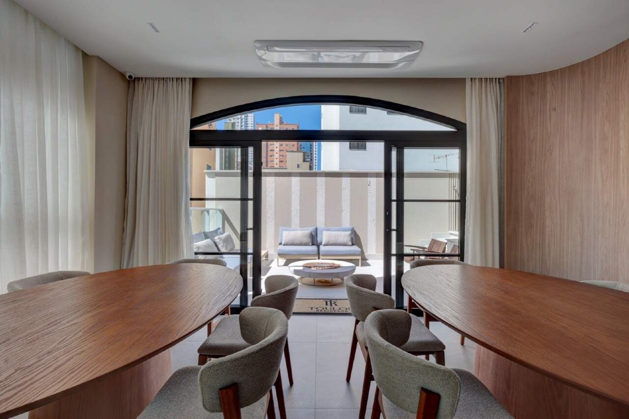 Apartamento à venda no Centro: Salão com mesas ovais e porta em arco para o terraço