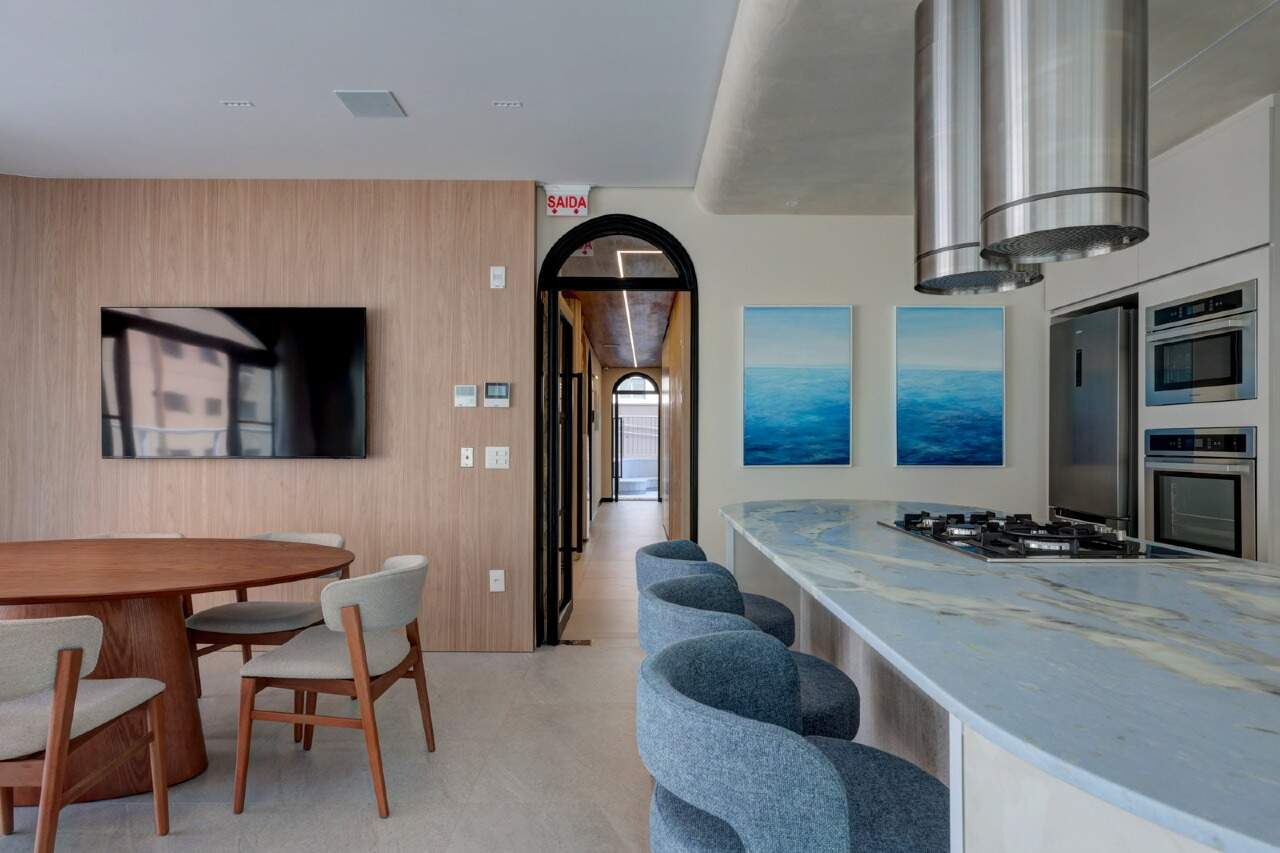 Apartamento à venda no Centro: Espaço gourmet com mesa redonda, bancada e banquetas azuis