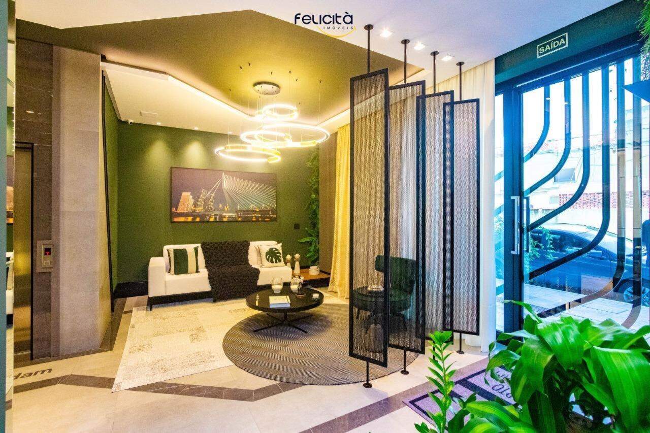 Apartamento à venda no Centro: Hall de entrada decorado, com poltronas e painel verde