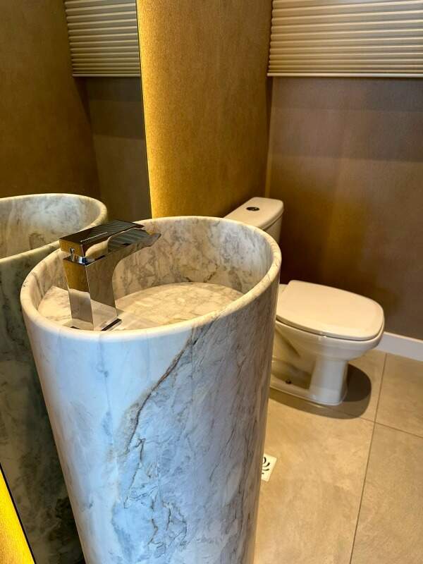 Apartamento à venda no Centro: Lavabo com cuba esculpida em mármore e iluminação indireta