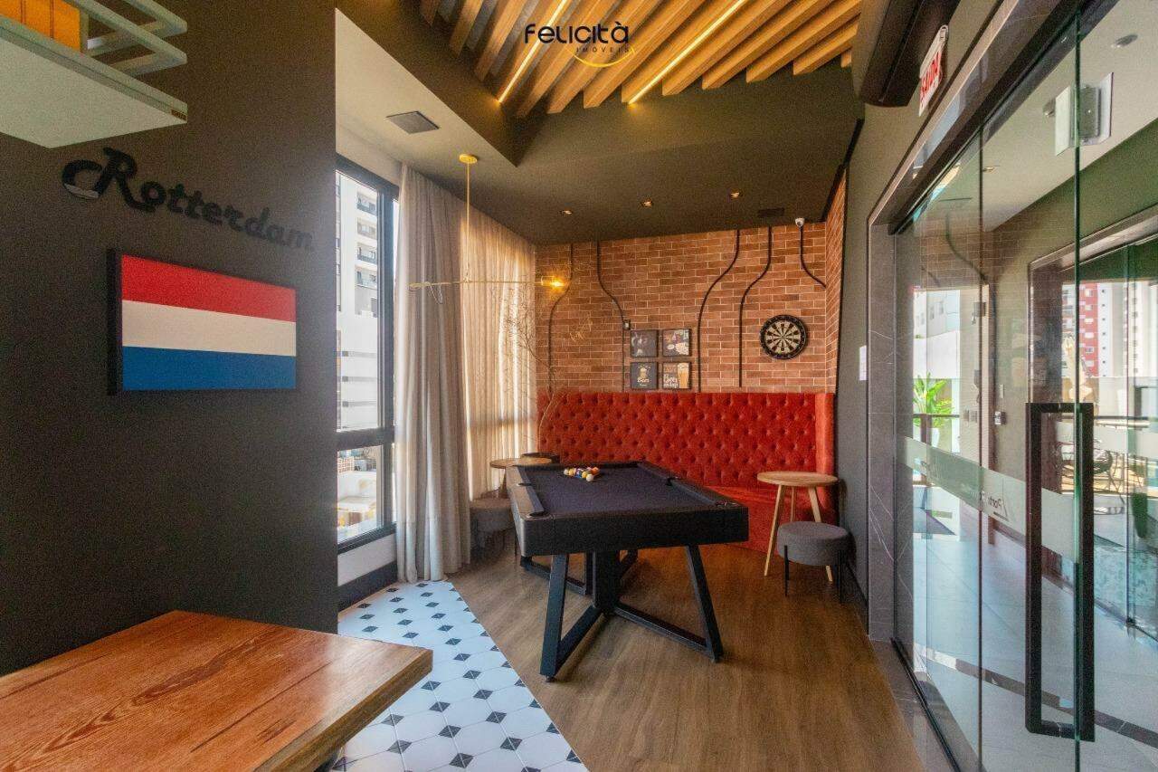 Apartamento à venda no Centro: Sala de jogos com mesa de sinuca, estofado vermelho e alvo de dardos