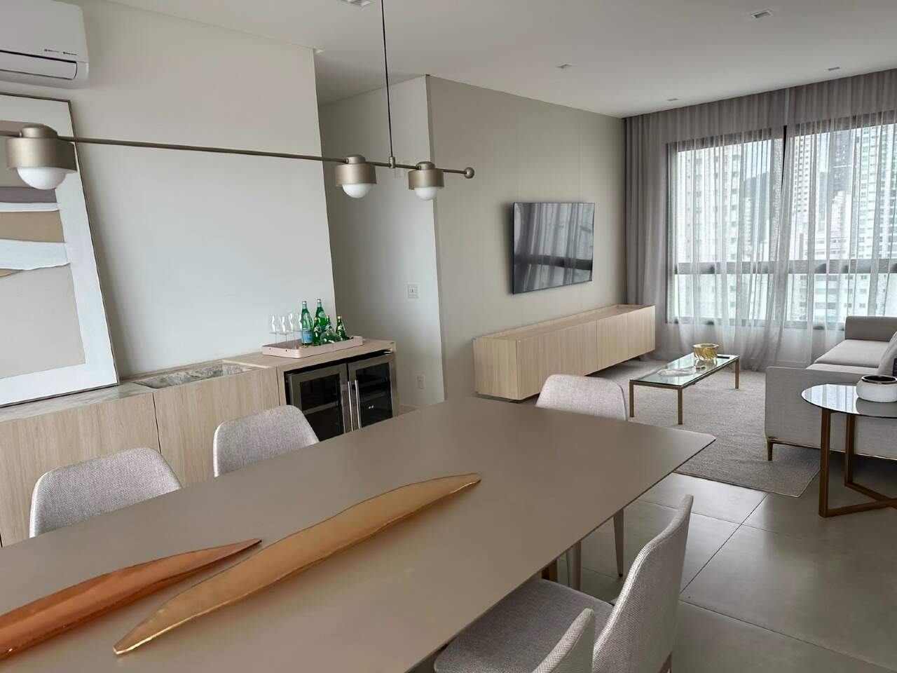 Apartamento à venda no Centro: Estar com painel de TV, poltronas e mesa de jantar