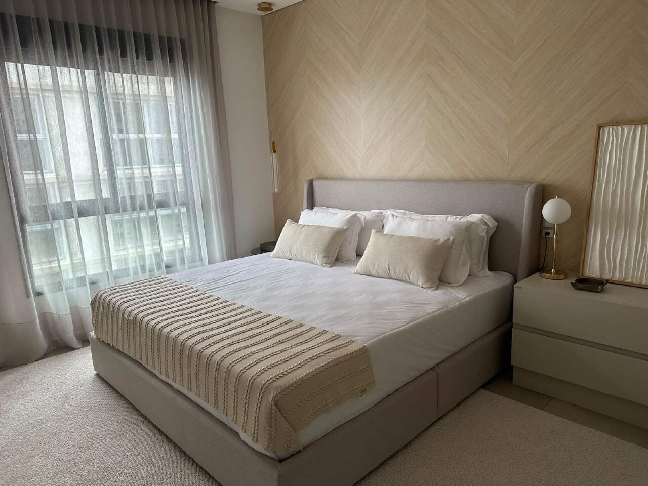 Apartamento à venda no Centro: Suíte de casal com cabeceira estofada e painel de madeira clara