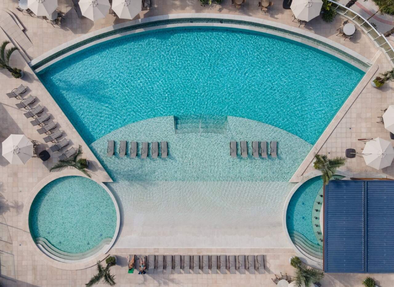 Apartamento à venda no Praia Brava: Vista aérea da piscina em semicírculo com prainha e espreguiçadeiras