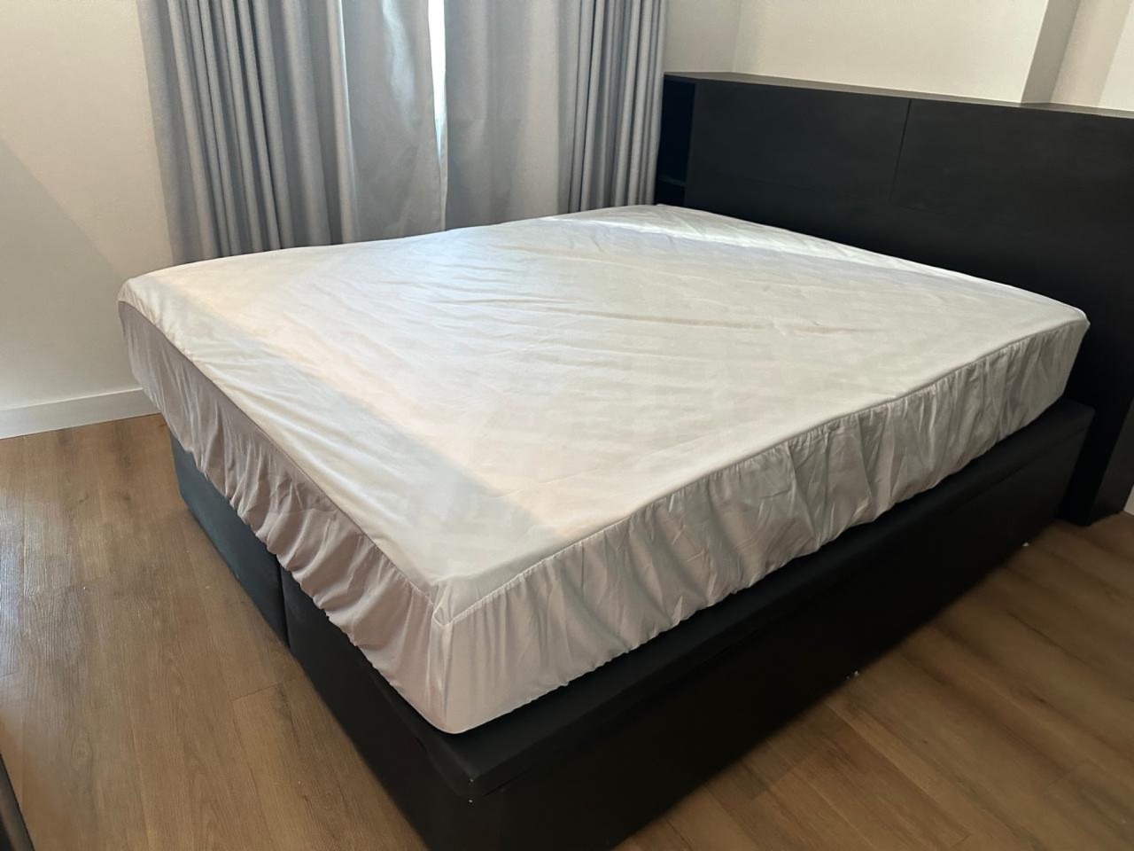 Apartamento à venda no Praia Brava: Cama com cabeceira escura e cortinas até o chão