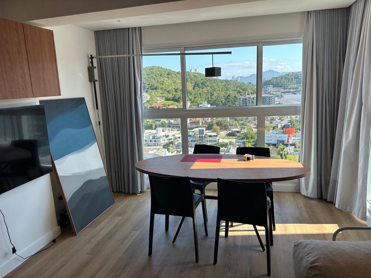 Apartamento à venda no Praia Brava: Living com mesa de jantar e janela ampla voltada para os morros da Praia Brava