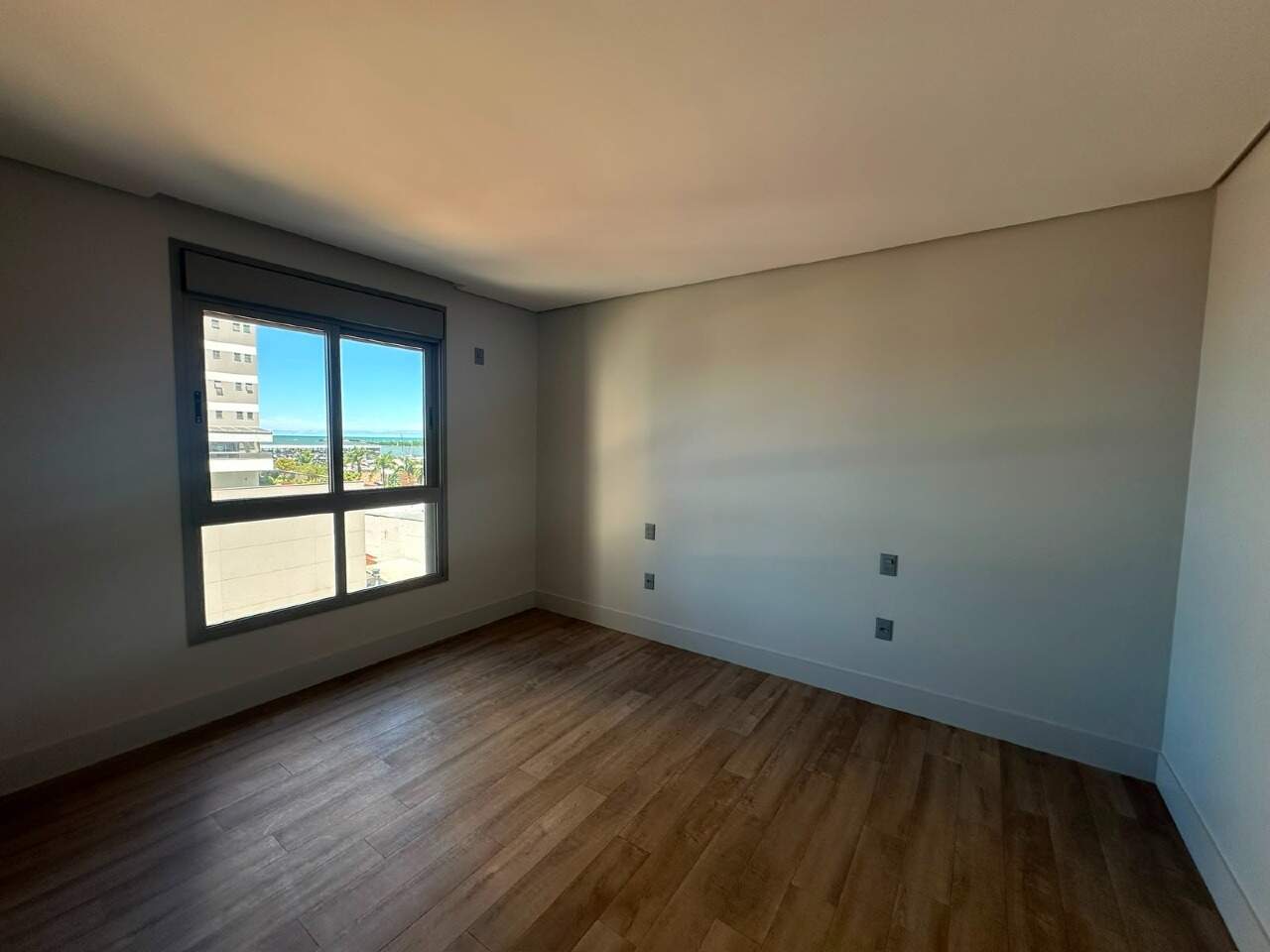 Apartamento à venda no Centro: Suíte com janela ampla e piso amadeirado