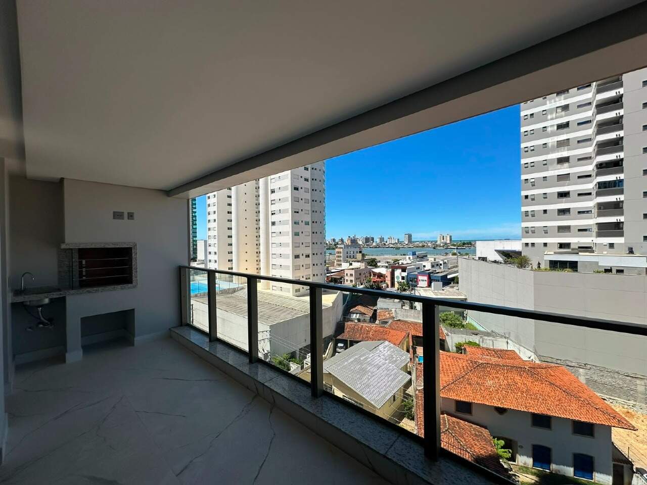 Apartamento à venda no Centro: Sacada com churrasqueira e guarda-corpo de vidro