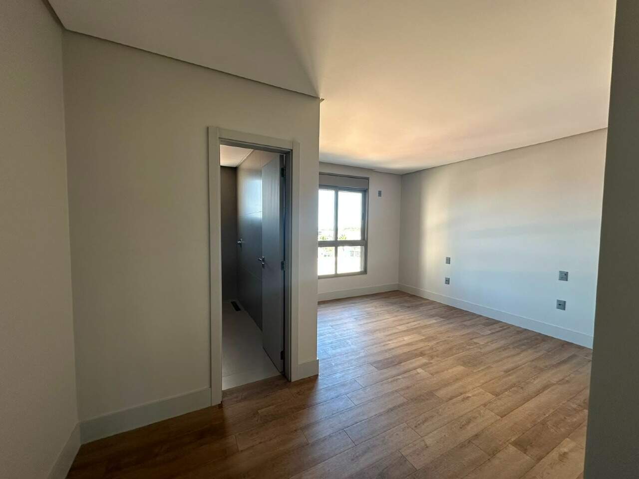 Apartamento à venda no Centro: Suíte com piso amadeirado e porta para o banheiro