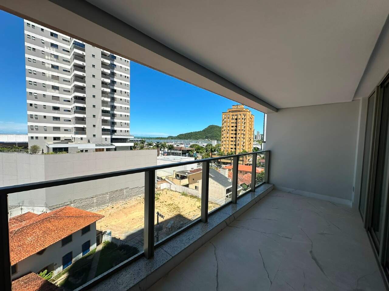 Apartamento à venda no Centro: Sacada com vista parcial para o Saco da Fazenda, os barcos e o morro, entre os prédios