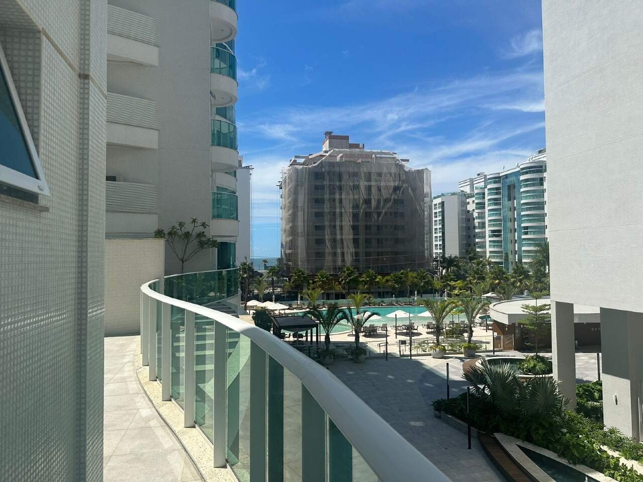 Apartamento diferenciado à venda no Praia Brava: Terraço curvo com guarda-corpo de vidro e vista para a piscina do condomínio