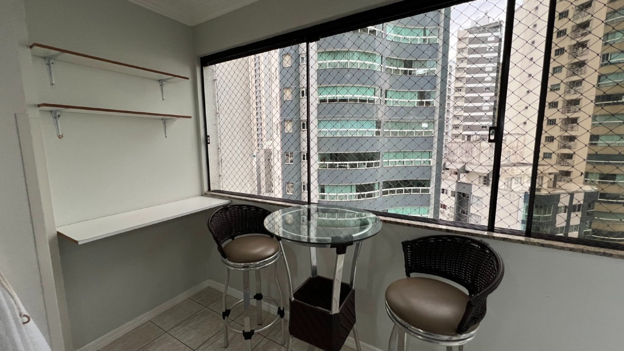 Apartamento à venda no Centro: Canto da sacada envidraçada com mesa alta e prateleiras