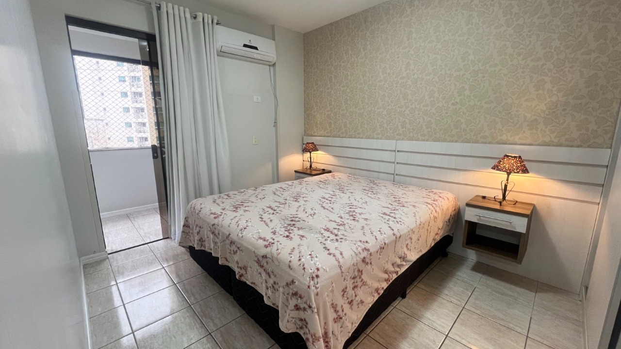 Apartamento à venda no Centro: Suíte com cama de casal, ar-condicionado e acesso à sacada