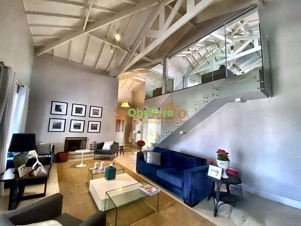 Casa de Condomínio à venda no Parque Delfim Verde: sala de estar com pé-direito duplo, lareira e mezanino de vidro